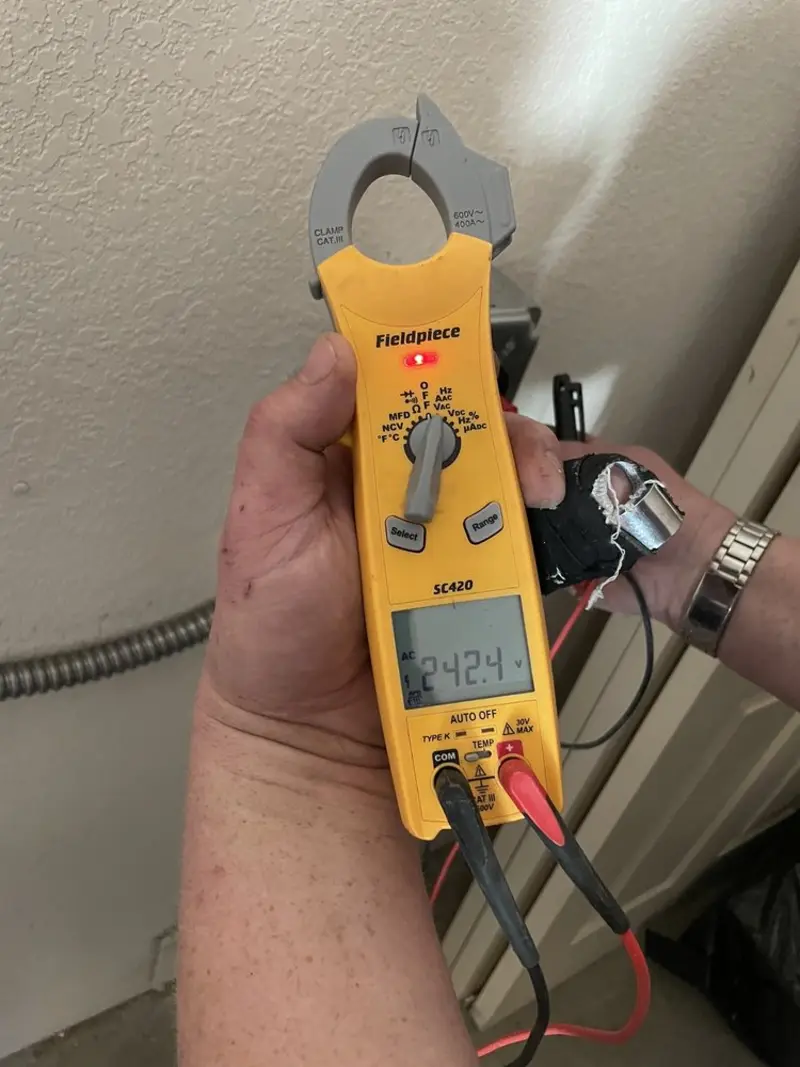 Voltage testing with clamp meter during Outlet Installation in Highland Village